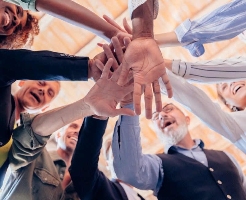 group gathers in a circle and gives energy with joined hands after a team building